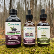 Four bottles of elderflower liquid extracts on a natural background