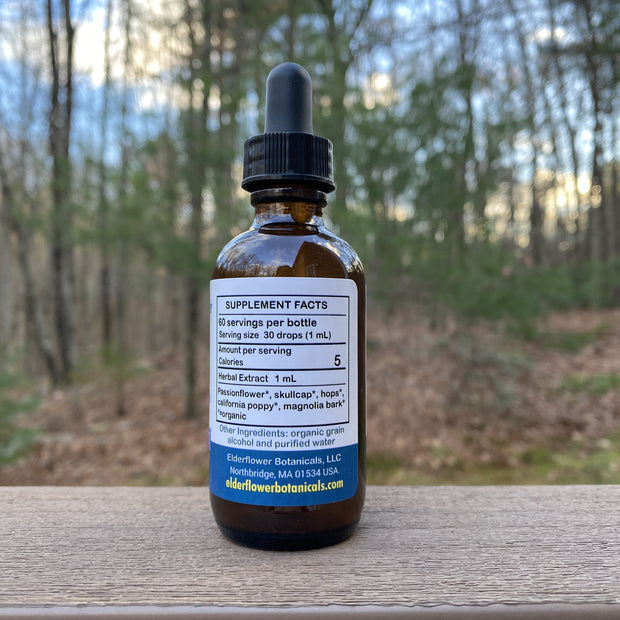 Bottle of supplement with dropper on a wooden surface outdoors