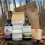 Collection of natural products including a bottle, soap, and other items on a wooden surface with a natural background.