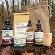 Collection of natural products including bottles and a bag on a wooden surface with leaves.