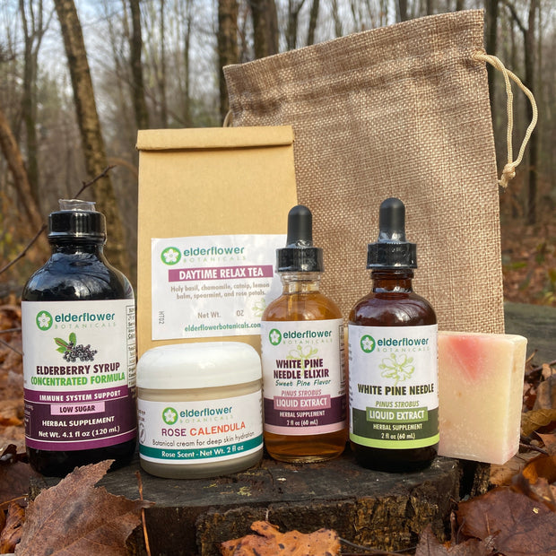Collection of natural products including bottles and a bag on a wooden surface with leaves.
