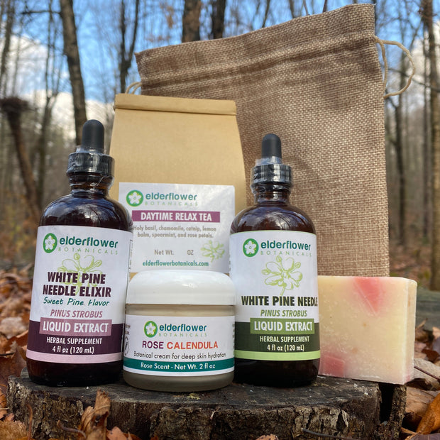 Herbal products including bottles and a bar of soap on a wooden stump with a natural background.